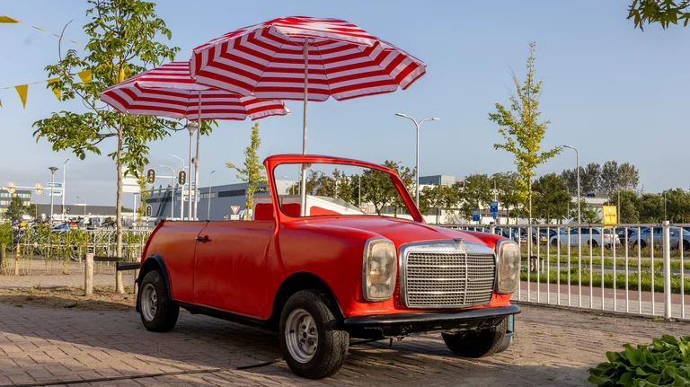 Rode MINI ijswagen met twee parasols op een schoolplein